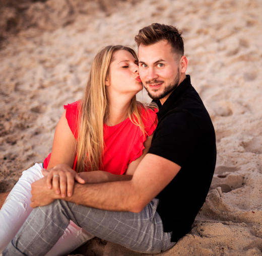 Paar am Strand Kuss auf Wange